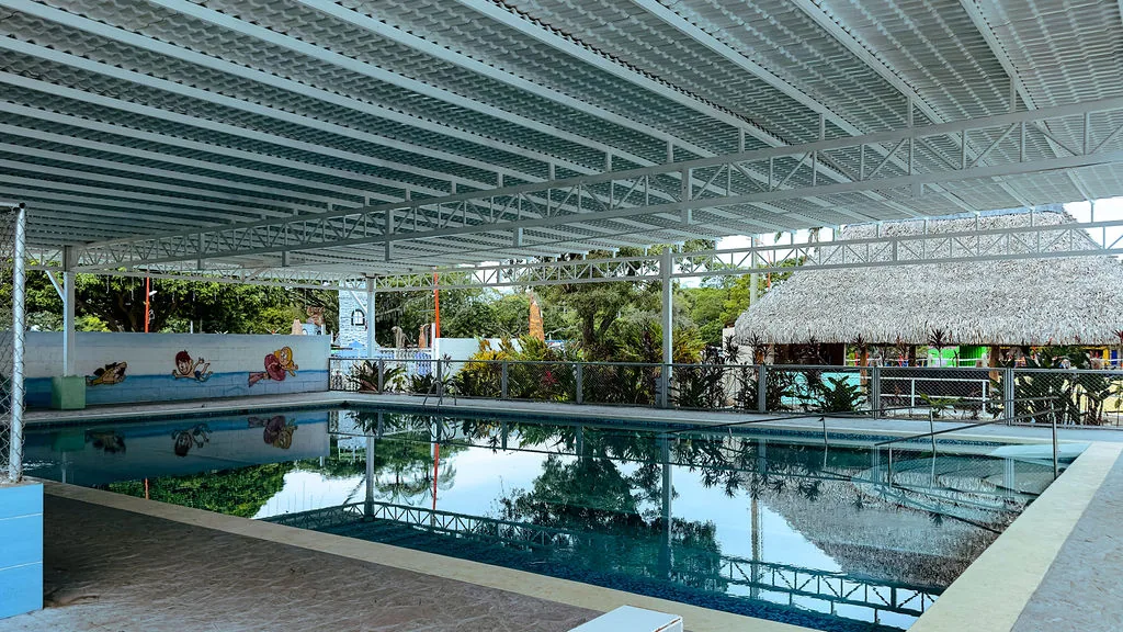 La piscina de hidroterapia bajo su techo, con la churuata al fondo